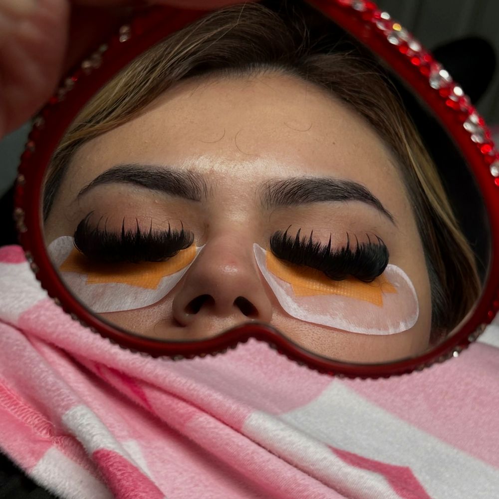 Wispy lash set seen in a red rhinestone heart mirror